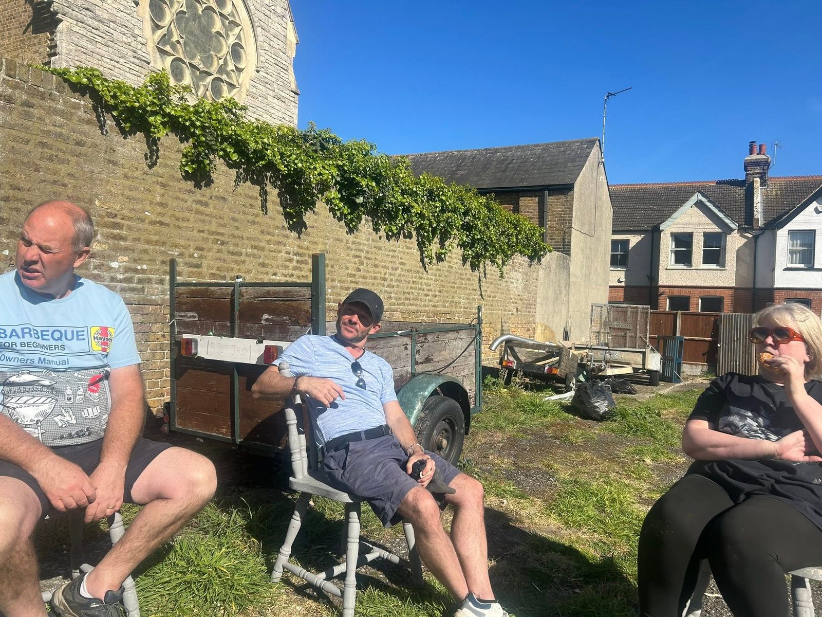 Three Theatrecraft members sitting outside in the sun taking a break from a work day
