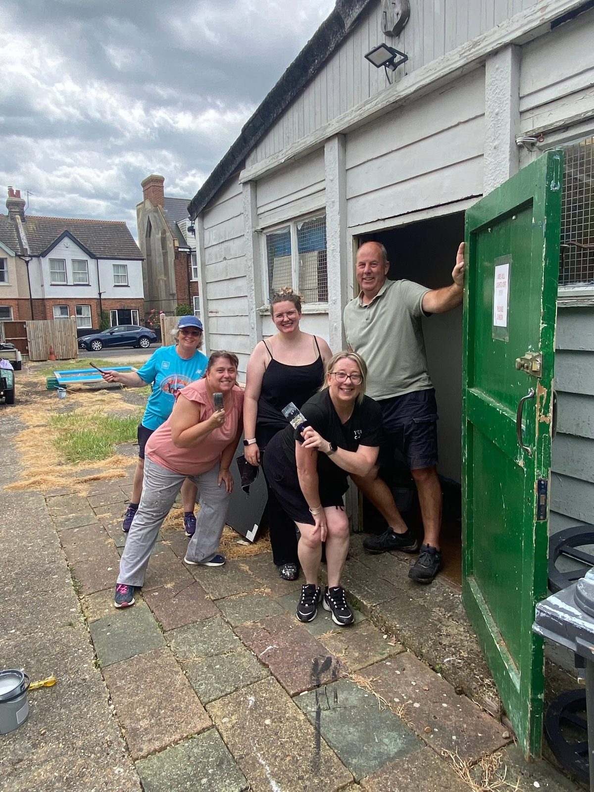 Five Theatrecraft members with paintbrushes outside the workshop door