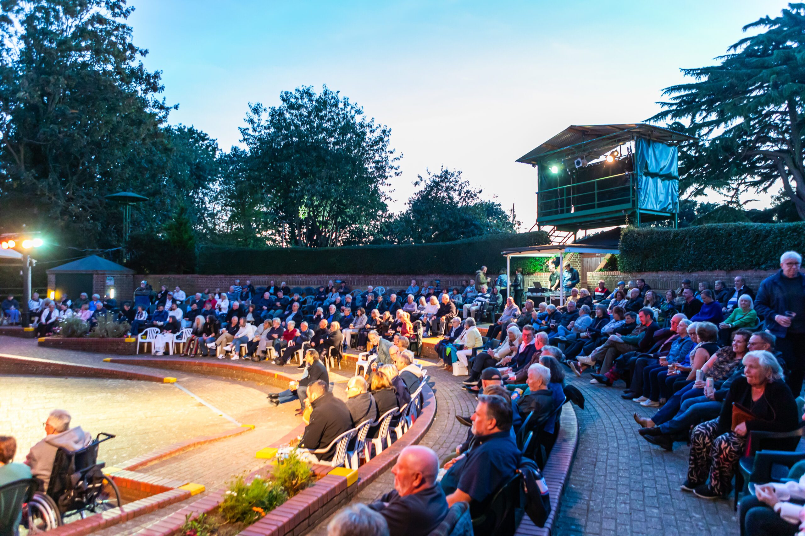 A packed audience enjoying a summer evening at the open-air theatre, Strode Park